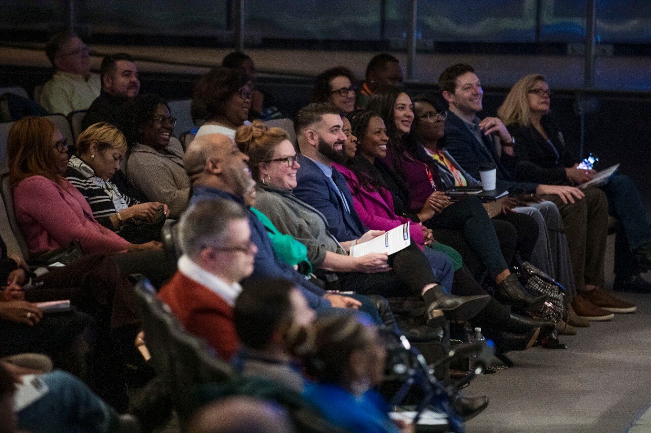 Ford Black History Month event with group of employees sitting in auditorium smiling at the presentation