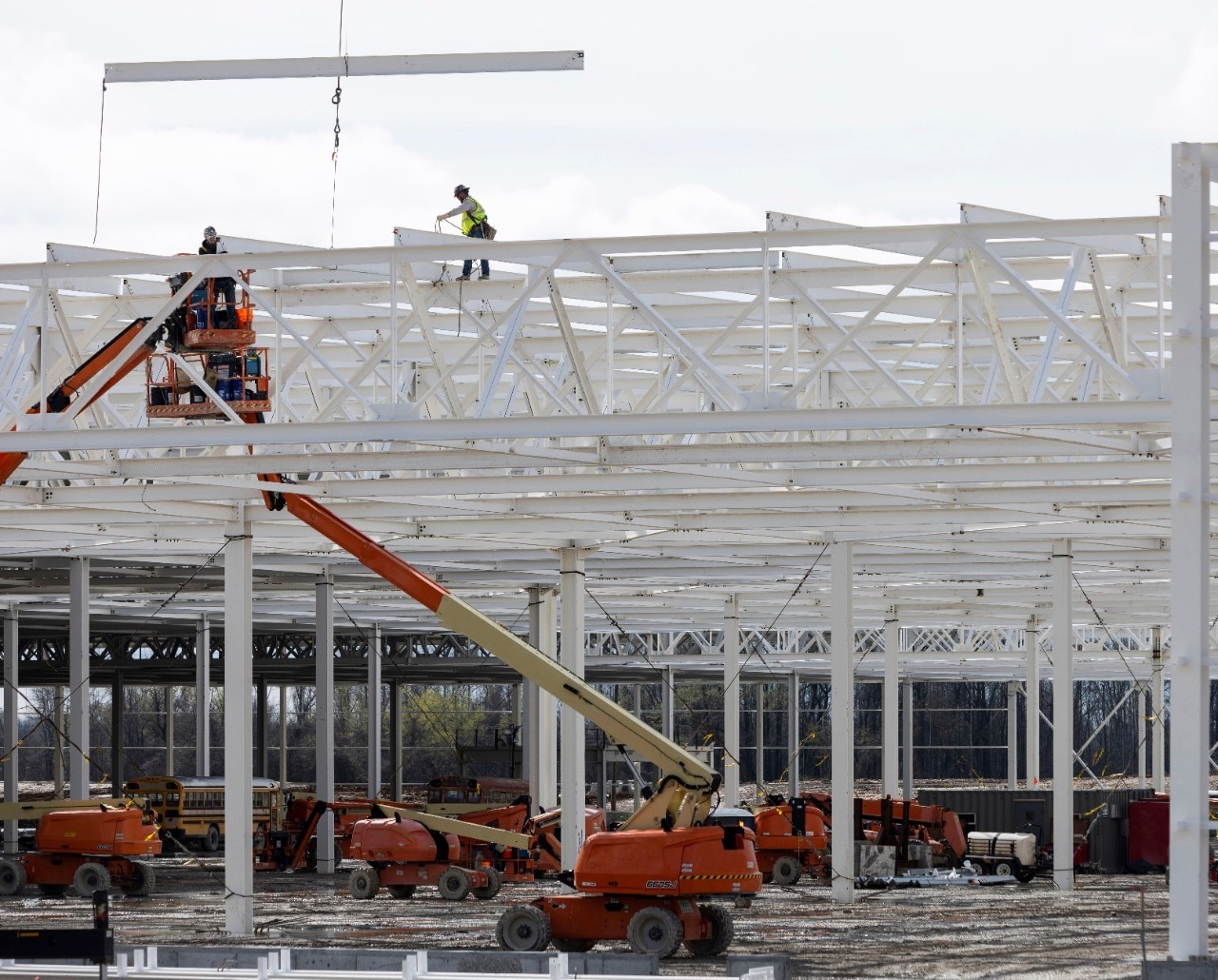 View of construction workers on unfinished roof of Blue Oval City facility